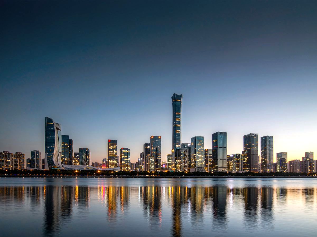 现代城市商务区楼群与水岸夜景（示意配图）